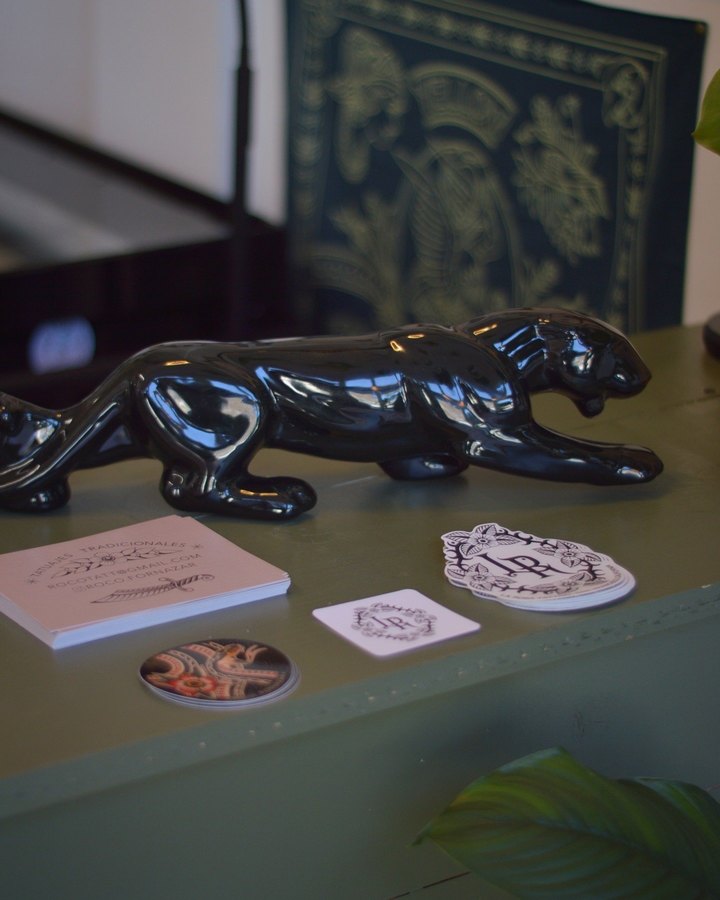 The front desk at La Rosa: a black panther statue, business cards and rose-monogram stickers on the counter.
